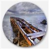 Designart 36-in x 36-in Old Rusty Pier in Cloudy Day Seashore Photo Circle Metal Wall Art